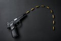 Black gun and yellow bullet on black background Royalty Free Stock Photo