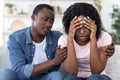 Black guy comforting his crying girlfriend, home interior