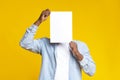 Black guy covering his face with white blank paper Royalty Free Stock Photo