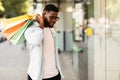 Black guy with shopping bags looking at mall window Royalty Free Stock Photo