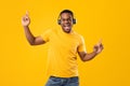 Black Guy Singing And Dancing Listening To Music, Yellow Background Royalty Free Stock Photo