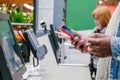 Black guy uses smartphone to pay at self-checkout point Royalty Free Stock Photo