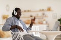 Black Guy Wearing Headphones Playing Virtual Guitar While Listening Music On Laptop Royalty Free Stock Photo