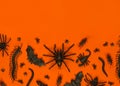 Black Halloween creepy bugs and spiders on orange background with blank space for text