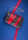 Black hand bag with red ribbon over the dark blue background Royalty Free Stock Photo