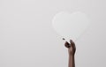 Black hand holding white heart sign on white background Showing love and friendship between people