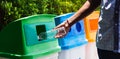 Black hand throwing an empty plastic water bottle in the recycling garbage trash Royalty Free Stock Photo