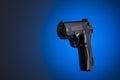 Black handgun isolated on blue background