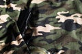 Black handgun wrapped in camouflage military fabric