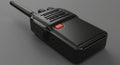 A black handheld walkie-talkie with a textured surface is shown. It features a red pus Royalty Free Stock Photo