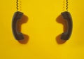 Black handsets on yellow background. Royalty Free Stock Photo