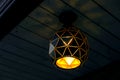 Black hanging lantern on wooden ceiling.