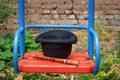 A black hat and a wooden sopilka lie on a swing in the playground.