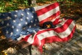 Black hat with a yellow maple leaf on a bench with an American flag Royalty Free Stock Photo
