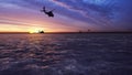 Black hawk military helicopters fly at sunrise across the boundless sea. 3D Rendering