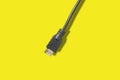 Black HDMI cable for connection between TV and laptop isolated on yellow background