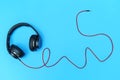 Black headphone and red cable on a blue background, Used in decoration and design Royalty Free Stock Photo