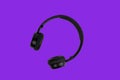 Black headphones isolated on trendy proton purple color background. Music minimal concept