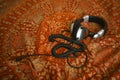 Headphones on red background. Close up. Indian canvas with ornament on background. Wallpaper. Music. Podcast. DJ. Ethnic