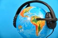 Black headphones with a microphone put on a globe Royalty Free Stock Photo