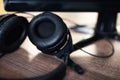 Black headphones with a microphone on a table near a computer. Workplace Royalty Free Stock Photo