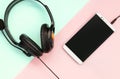 Black headphones and smartphone lies on a colorful pastel pink background Royalty Free Stock Photo