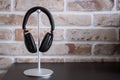 Black headphones on stand against brick wall Royalty Free Stock Photo