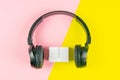 Black headphones and wooden cubes on a yellow and pink background. On cubes you can enter your date, month and day Royalty Free Stock Photo