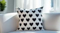 Black heart patterned pillow rests on a white couch Royalty Free Stock Photo