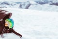 Black helmet with skiing goggles on snow with white snowy mountains landscape background