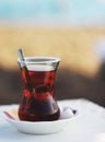 Black herbal turkish tea in traditional glass at the beach