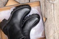 black high women& x27;s boots with thick soles lie in a box on an old board on the street, women& x27;s winter shoes Royalty Free Stock Photo