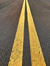 Asphalt road with yellow strips for lanes demarcation