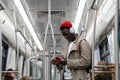 Black hipster man wear wireless headphones, listening to the music, using smartphone in subway train Royalty Free Stock Photo