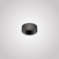 Black hockey puck on a grey background