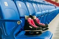 Black hockey skates with ping bootlaces on the chair on the empty stadium Royalty Free Stock Photo