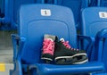 Black hockey skates with ping bootlaces on the chair on the empty stadium. Chair has a number one. Royalty Free Stock Photo