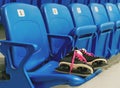 Black hockey skates with ping bootlaces on the chair on the empty stadium. Rows have a numeration. Royalty Free Stock Photo