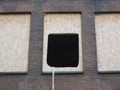 Black hole cut out in a piece of wood in an old window of a house being renovated Royalty Free Stock Photo