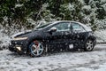 Black Honda Civic with Snow Chains on Front Wheels During Heavy Snowfall on Winter Season