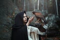 Black hooded huntress with hawk Royalty Free Stock Photo