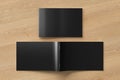 Black horizontal brochure or booklet cover mock up on wooden background. Closed one brochure and upside down other. Royalty Free Stock Photo