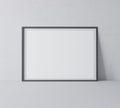 Black horizontal frame mock up. Frame poster standing on gray floor.