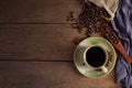 Black hot fresh coffee in brown ceramic cup with coffee beans roasted in burlap sack bag on wooden table background. Royalty Free Stock Photo