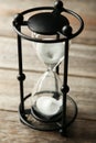 Black hourglass on a grey wooden background Royalty Free Stock Photo