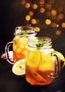 Black ice tea with lemon slice in glass jar on dark kitchen table background, summer cool soft drink, selective focus Royalty Free Stock Photo