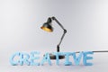 Black industry style desk lamp on grey colored surface with clay stylized lettering creative; concept 3D artist design; 3D