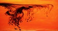 Black ink dispersing in orange water