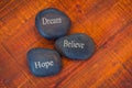 Black inspirational pebble stones with the words Dream, Believe Royalty Free Stock Photo