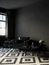 Black interior with leather armchair, coffee table and decor. Royalty Free Stock Photo